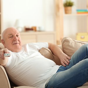 bigstock-Fat-senior-man-watching-TV-whi-191930461.jpg